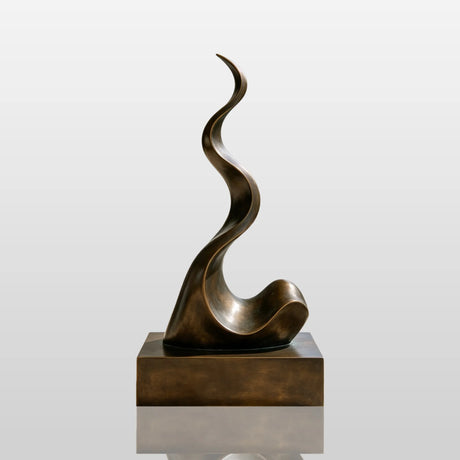 A wavy abstract bronze sculpture stands on the terrace of a modern home with glass railing.