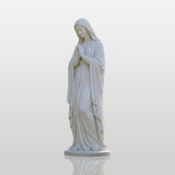 Marble Virgin Mary statue stands on green grass beside a church.