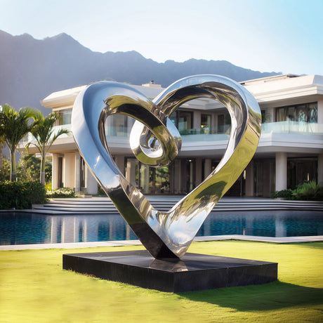 Stainless steel heart sculpture with flowing modern design in a luxury outdoor space.