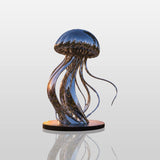 Shiny stainless steel jellyfish statue sits on a coastal flower bed with ocean sunset.