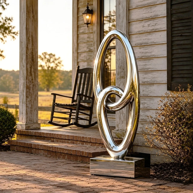 Reflective interlocked ring stainless steel sculpture stands on the residential front porch.