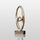 Reflective interlocked ring stainless steel sculpture stands on the residential front porch.