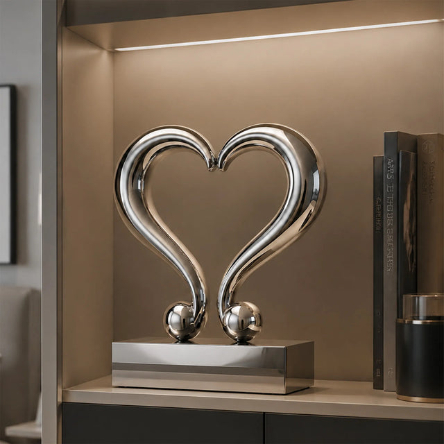 Polished stainless steel heart tabletop sculpture sits inside a display cabinet.