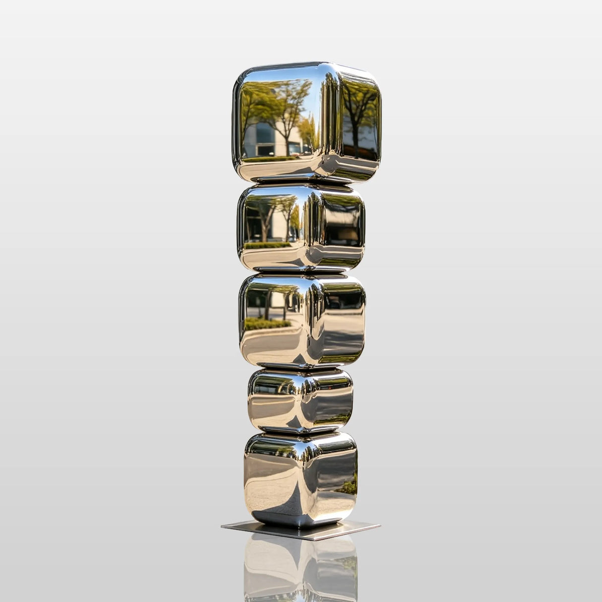 Mirror stacked cube stainless steel sculpture stands on city sidewalk outside a modern building.