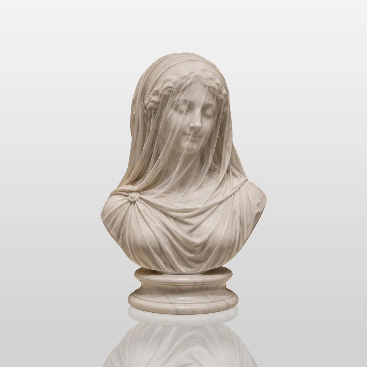 Exquisitely carved translucent veiled lady marble bust sits inside a muted paneled art gallery room.