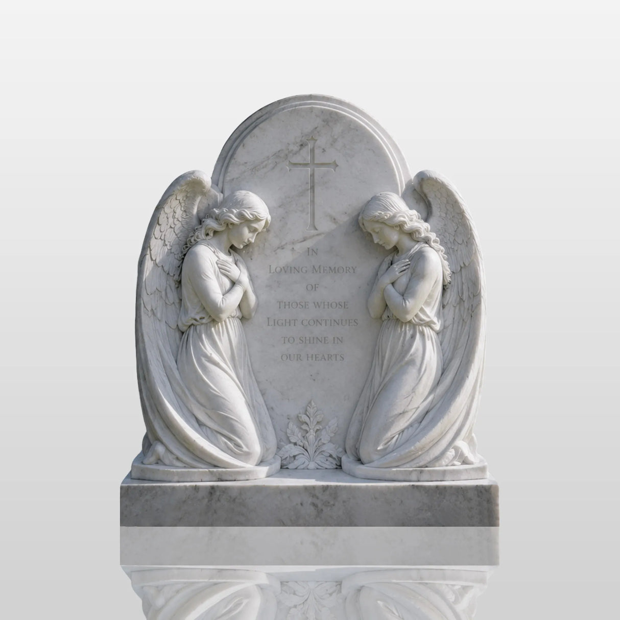 White marble tombstone carved with two kneeling praying angels and central cross sits on green grass within a cemetery.
