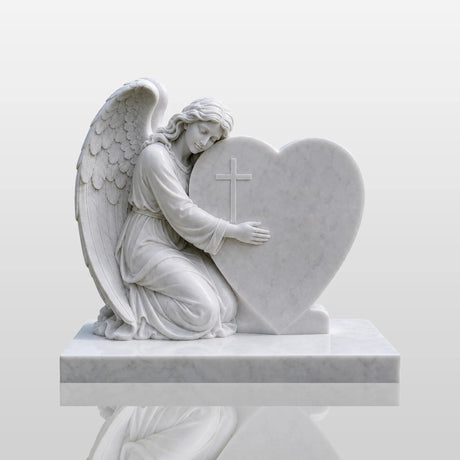 Marble tombstone featuring an angel embracing a heart rests on the cemetery lawn.